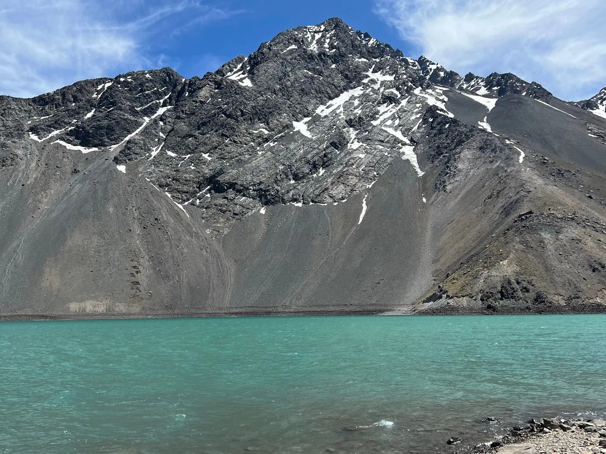 Close view of turquoise glacial water against a snow-streaked Andean peak, representative of Embalse El Yeso's colour